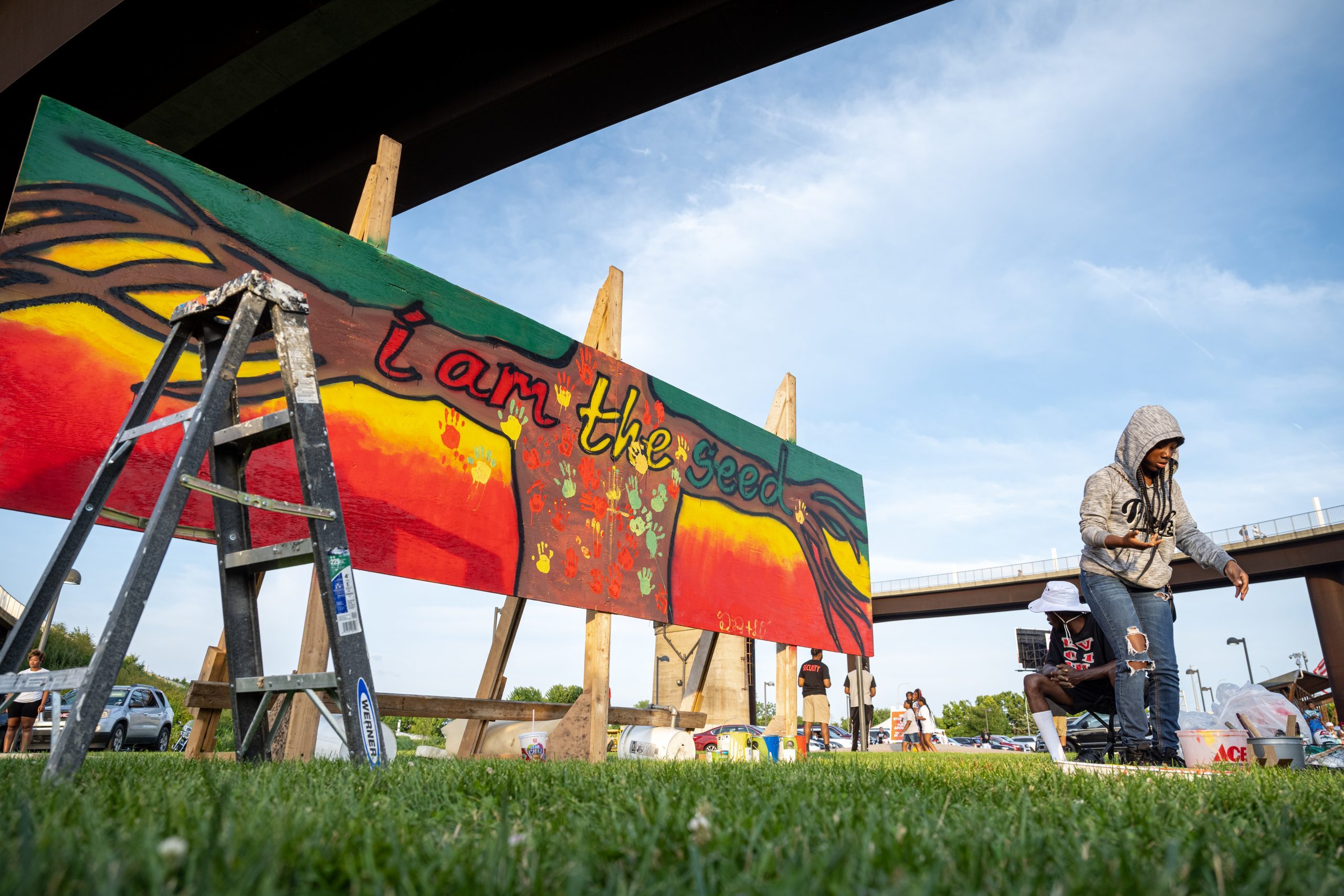 A young woman stands near a piece of art created during the Louisville Juneteenth Festival at the Big Four Lawn on June 19, 2021 in Louisville, Kentucky