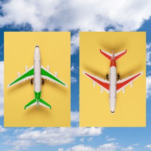 Two model airplanes display green and red designs on yellow backgrounds against a blue sky with clouds.