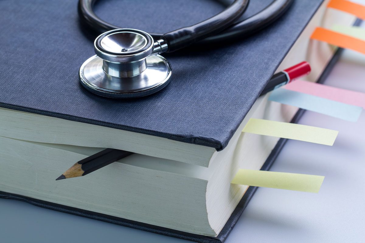 Medical Student Textbook With Pencil And Multicolor Bookmarks And Stethoscope