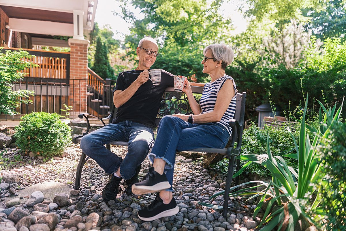 Senior couple having a coffee break in the home garden